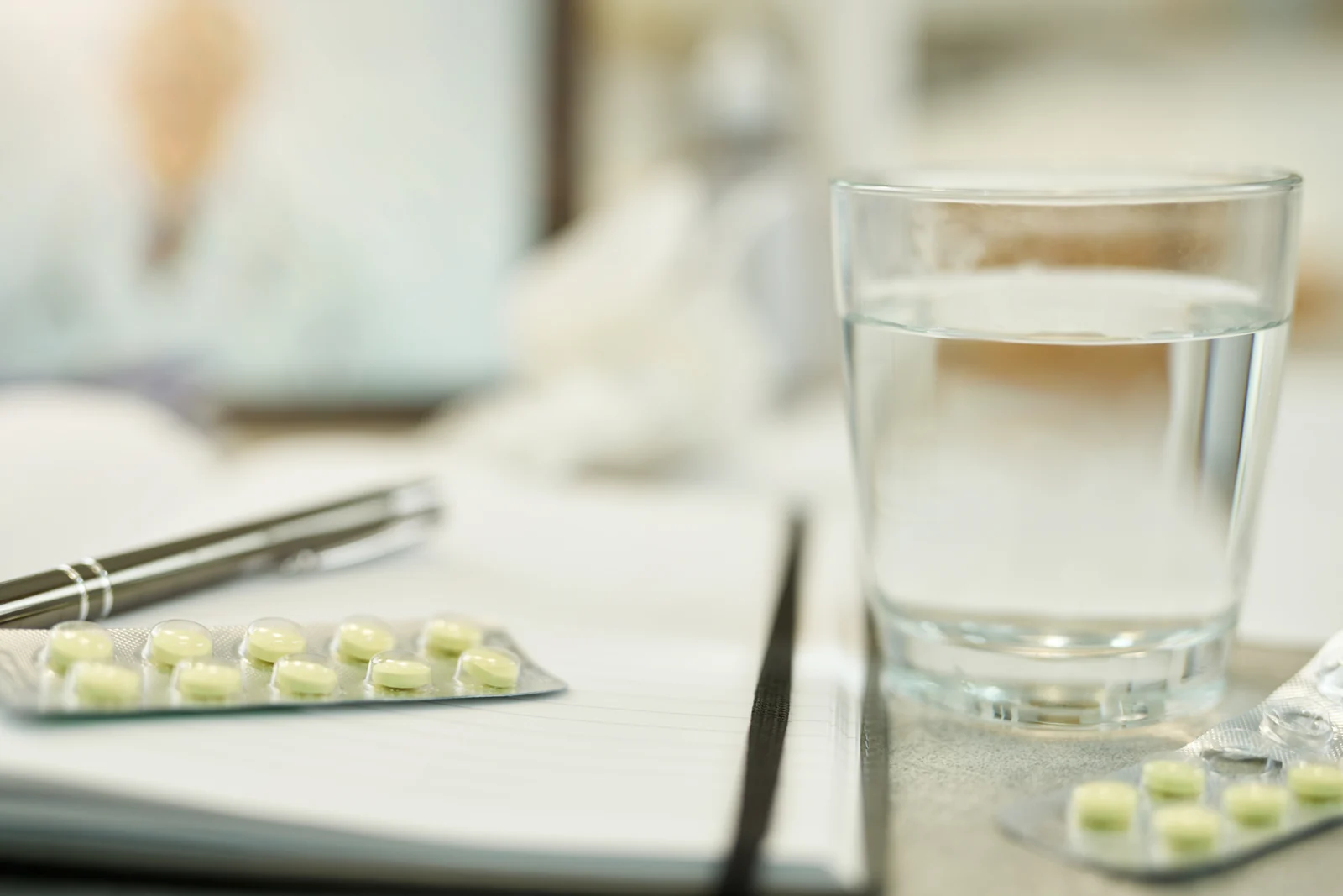 Pills and Water on a White Notepad