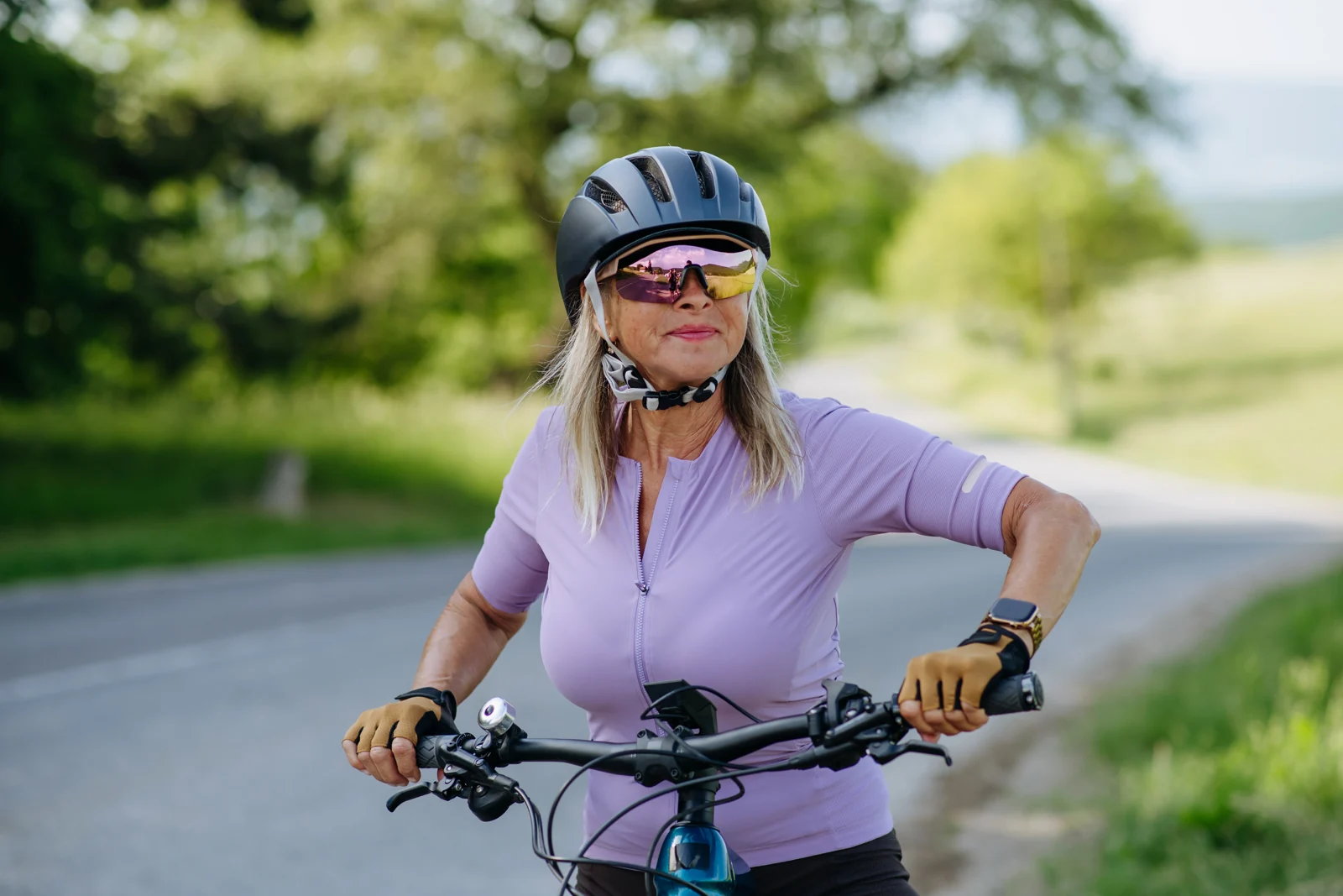 Senior Woman Cycling on a Rural Road in Daytime