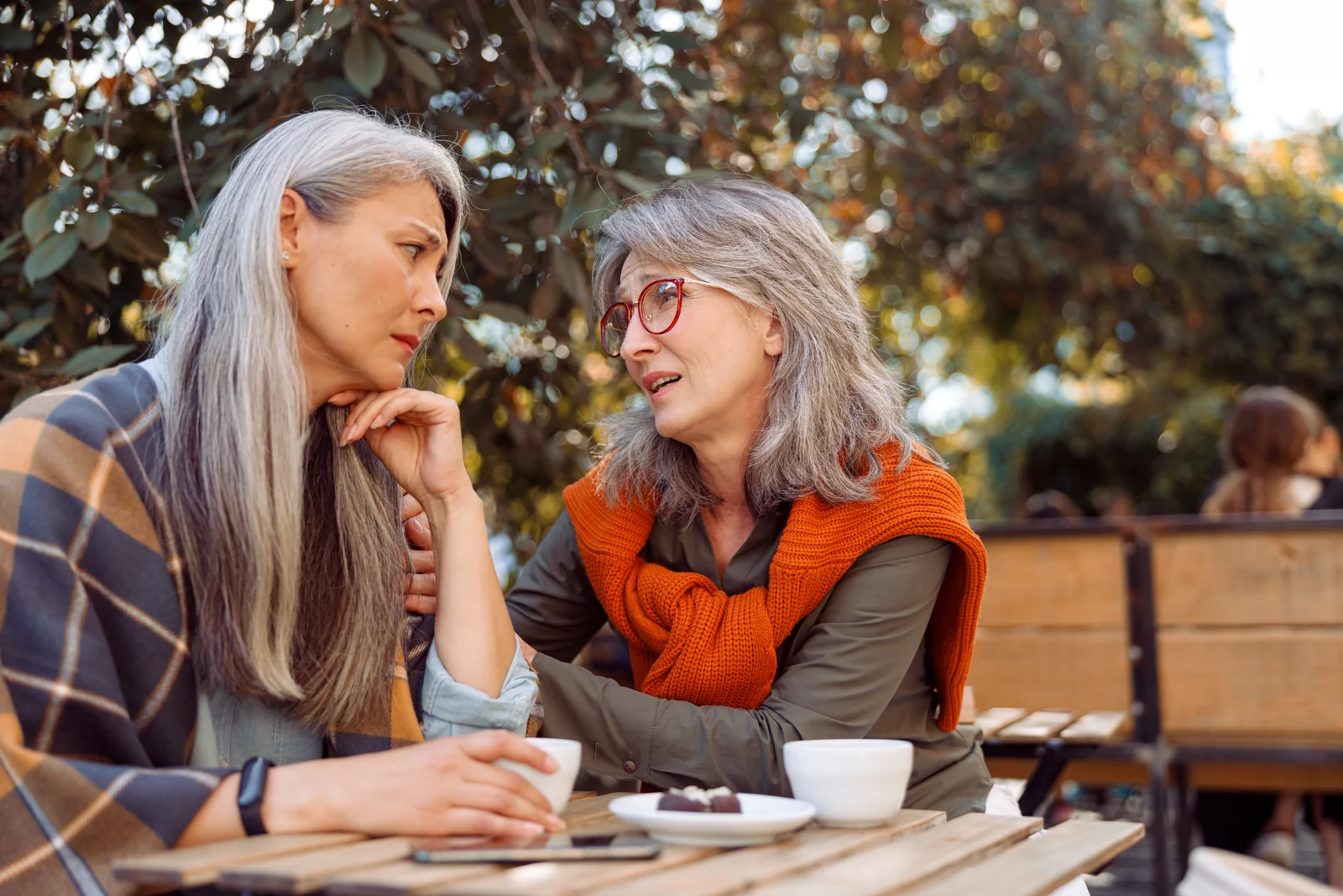 Two Senior Women Talking Over Coffee Outdoors